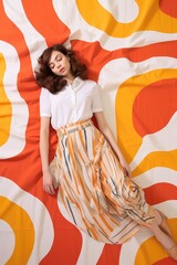 Beautiful young woman in vibrant clothing lies on a brightly colored bedspread. A fictional character created by Generated AI