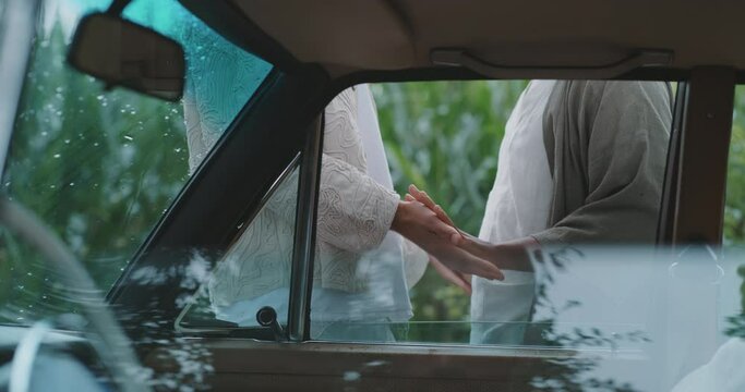 queer men hands touching each other outside a car. 
