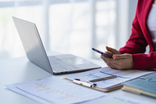 Female accountant analyzing charts, graphs, computer, investment tablet and pressing calculator button above document. Accountants, accountants, clerks, bank consultants and auditors. close-up photo