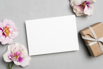 Beautiful greeting card mockup with gift box and flowers, blank card with copy space for design