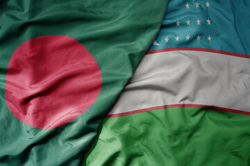 Obraz premium big waving realistic national colorful flag of bangladesh and national flag of uzbekistan .