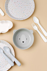 Cute children's plates and dishes shape of a bear. Creative serving for baby. Concept of kids menu, nutrition and feeding.