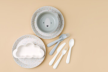 Cute children's plates and dishes shape of a bear. Creative serving for baby. Concept of kids menu, nutrition and feeding.