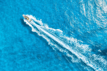 Aerial view on fast boat on azure Mediterranean sea at sunny day. Fast ship on the sea surface. Seascape from the drone. Seascape with motorboat. Vacation and leisure.
