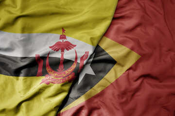 big waving realistic national colorful flag of brunei and national flag of east timor .