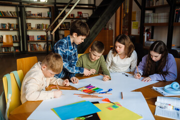 Group of children drawing during art lesson in library