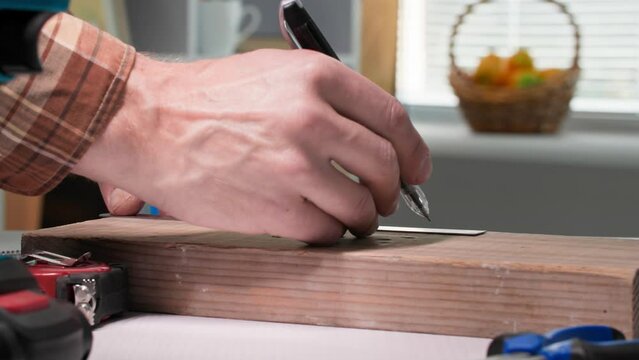 homework, male furniture assembler screwing a metal corner to a wooden board on a table in room