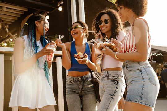 Group Of African Women Eating Bubble Waffles In Park