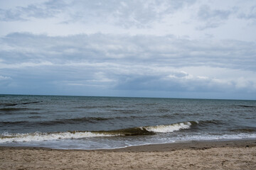 die Ostsee mit Strand vor einem bewölkten Himmel