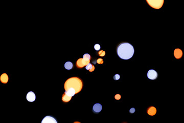 Blue and yellow festive bokeh lights on black background