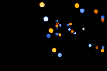 Blue and yellow festive bokeh lights on black background