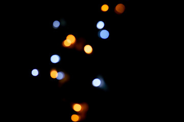 Blue and yellow festive bokeh lights on black background