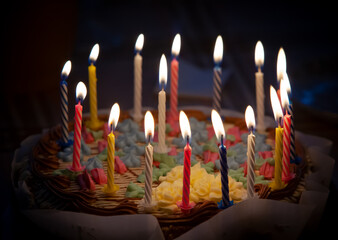 A birthday cake bought in a pastry shop for my grandmother's birthday is decorated with many colorful candles.