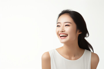 Fototapeta premium A close-up shot of a radiant young Asian woman, smiling with impeccable teeth. Designed for a dental promotion. With a white background. Crafted following the rule of thirds. Generative AI.