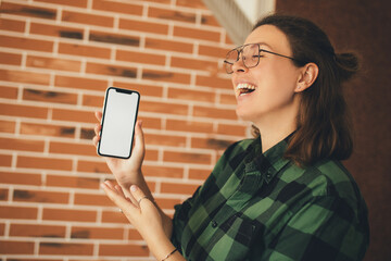 Woman holding smartphone with white empty screen. Place for text.
