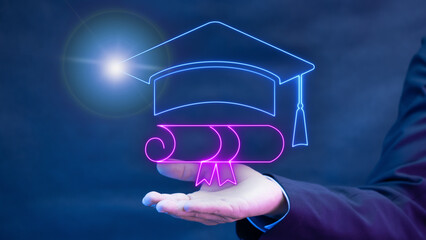 Businessman hand shows glowing neon line of graduation cap with tessel icon. E-learning online,...