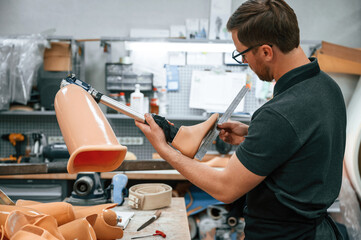Leg prosthesis in hands. Technician working indoors