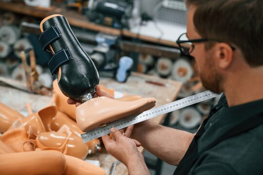 Measuring the prosthesis. Technician working in modern laboratory