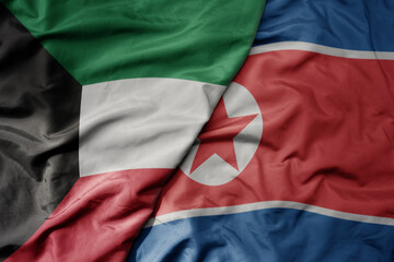 big waving realistic national colorful flag of kuwait and national flag of north korea .