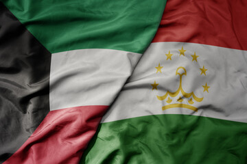 big waving realistic national colorful flag of kuwait and national flag of tajikistan .
