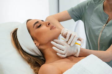Making injection. Woman face getting facial care by beautician at spa salon