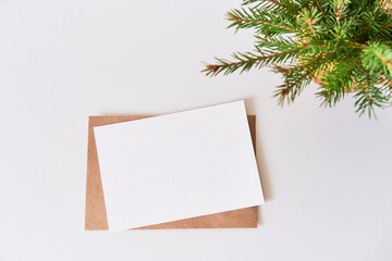 Blank paper on craft envelope, bouquet of christmas tree branches.