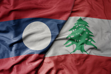 big waving realistic national colorful flag of laos and national flag of lebanon .