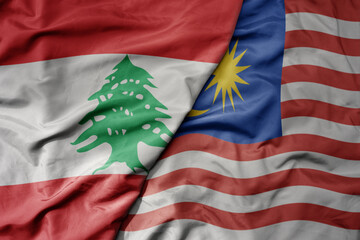 big waving realistic national colorful flag of lebanon and national flag of malaysia .