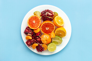 Creative flatlay layout of juicy pomegranate and citrus