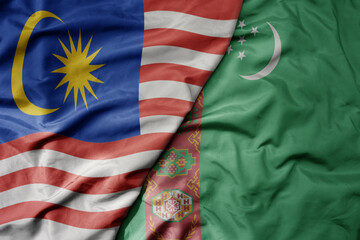 big waving realistic national colorful flag of malaysia and national flag of turkmenistan .