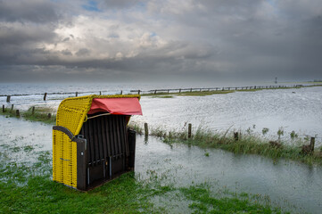 Beach chairs at the beach of Altenbruch near Cuxhaven in Germany. Beach flooded after a summer...