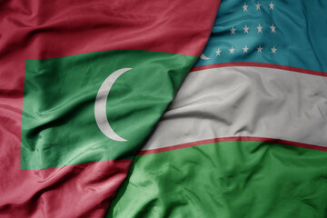 big waving realistic national colorful flag of maldives and national flag of uzbekistan .