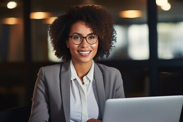 young happy professional african american business woman sitting at desk
