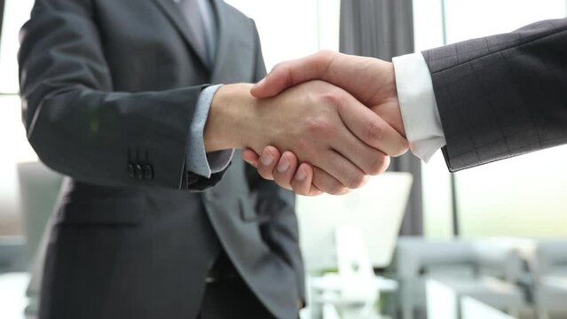 Building a strong business network. two businessmen shaking hands in a modern office