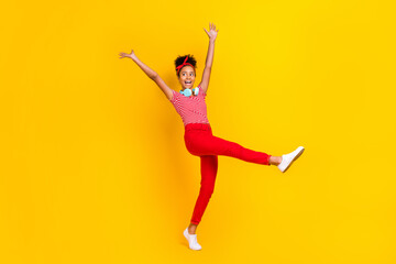 Fototapeta na wymiar Full length photo of little carefree overjoyed girl dancing look empty space hang neck headphones isolated on yellow color background