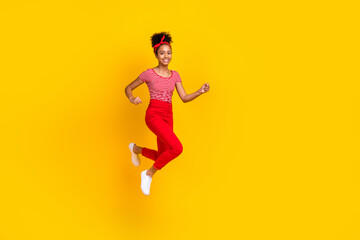 Fototapeta na wymiar Full body photo of pretty young girl jump run fast hurry sales dressed stylish red striped outfit isolated on yellow color background