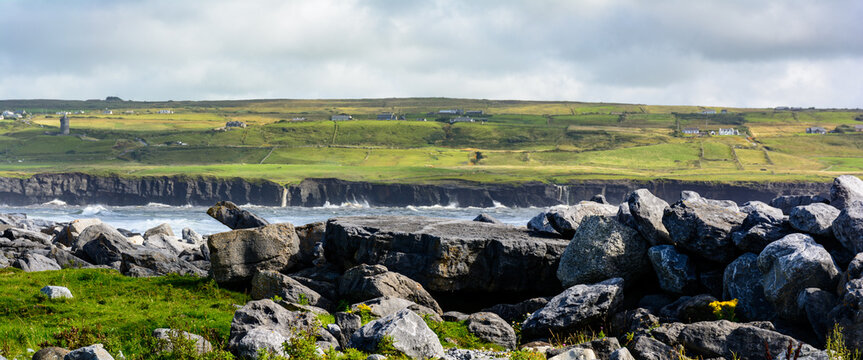 Scogliera irlandese sullo fondo vita da una spiaggia delimitata da grossi scogli (Irlanda, Doolin)