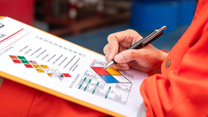 A safety engineer is using pen to rating the health risk assessment level of chemical hazardous...