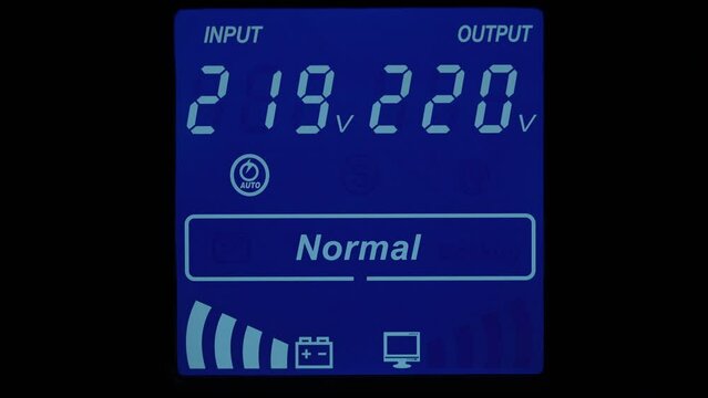 Close up of blue digital display on uninterruptible power supply with automatic voltage stabilizer