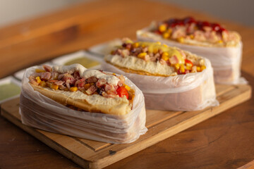 Delicious hot dog with ingredients and on colorful or wooden background.