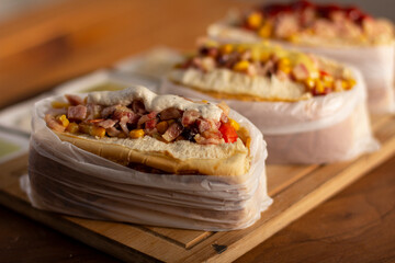 Delicious hot dog with ingredients and on colorful or wooden background.