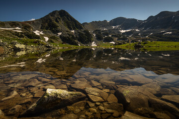 Lake in the middle of mountains with reflection, Retezat Carphatian Romania