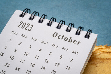 October 2023 - closeup of a small desktop calendar, time and business concept