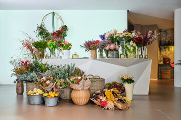 Various blooming flowers placed on counter and floor in floral s