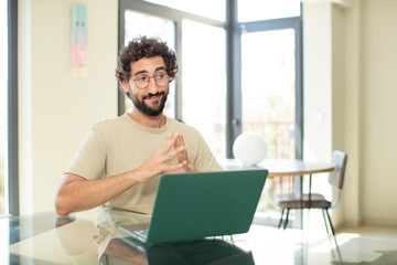 young adult bearded man with a laptop scheming and conspiring, thinking devious tricks and cheats