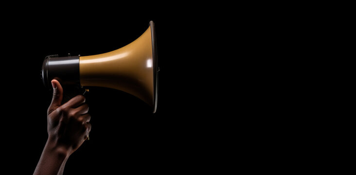 Generative AI, golden megaphone in hand on a empty black background, panoramic image with copy space