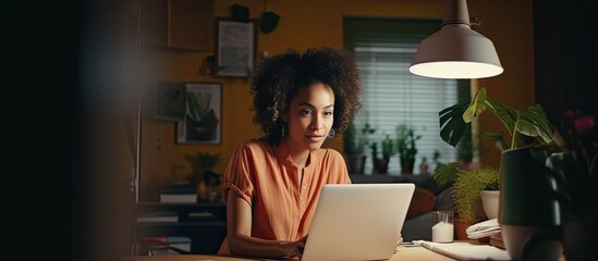 Biracial woman working remotely from home using laptop for business
