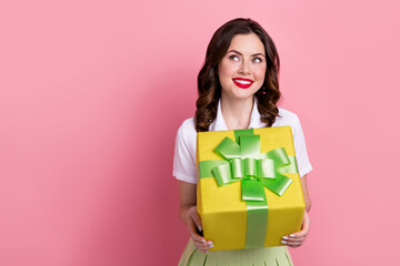 Photo of sweet dreamy woman dressed white shirt holding present box looking empty space isolated pink color background