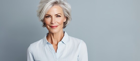 Smart stylish older woman with gray hair in a bright studio setting with room for text - obrazy, fototapety, plakaty