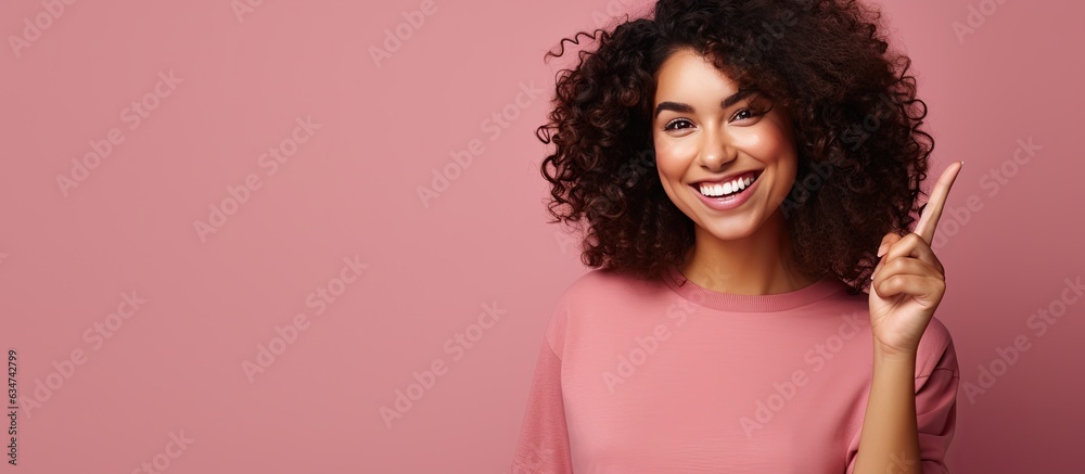 Poster smiling cheerful hispanic woman pointing upwards with object in space